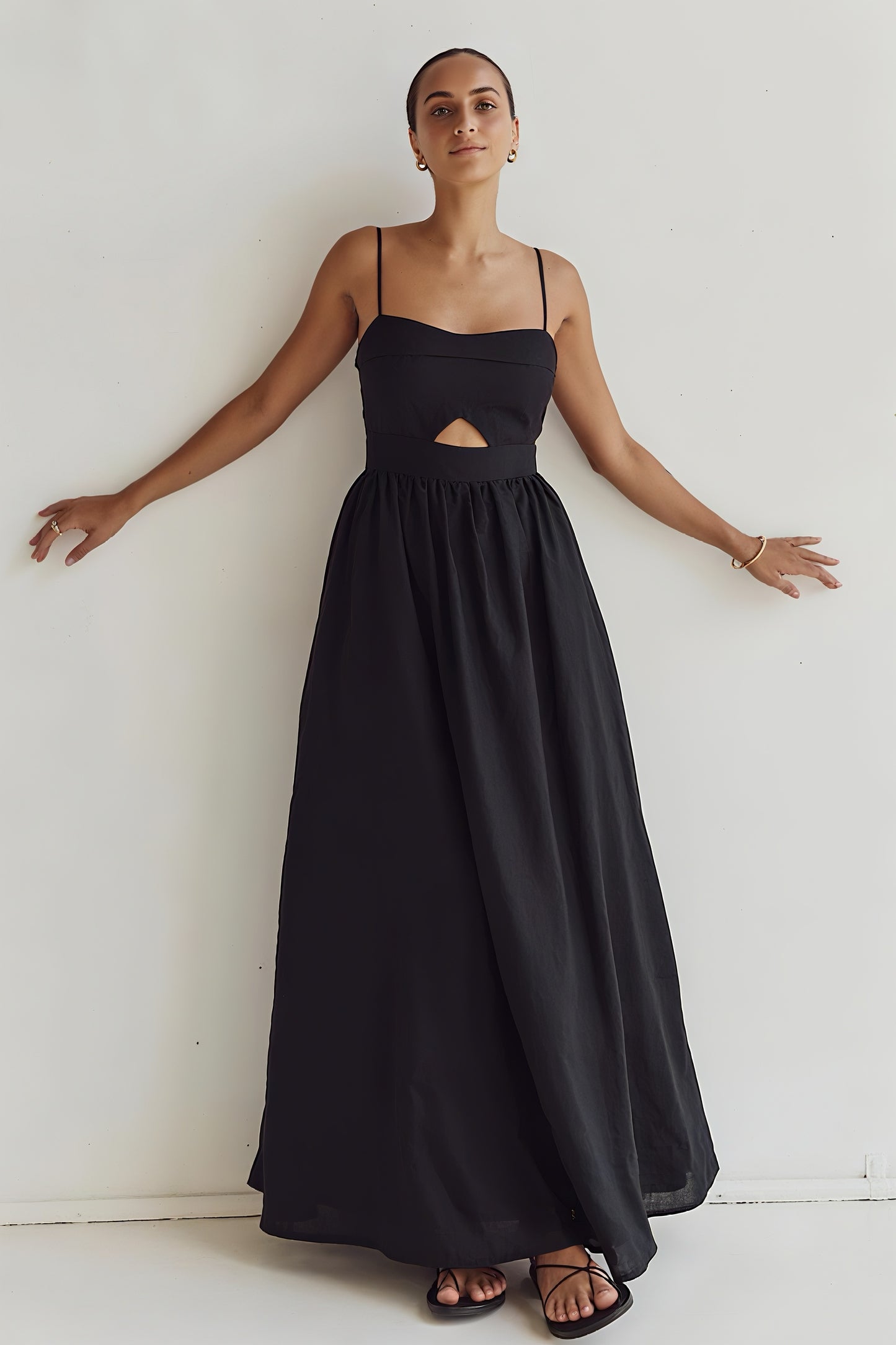 Woman wearing the black Kaia Dress with spaghetti straps and front cut-out – front view