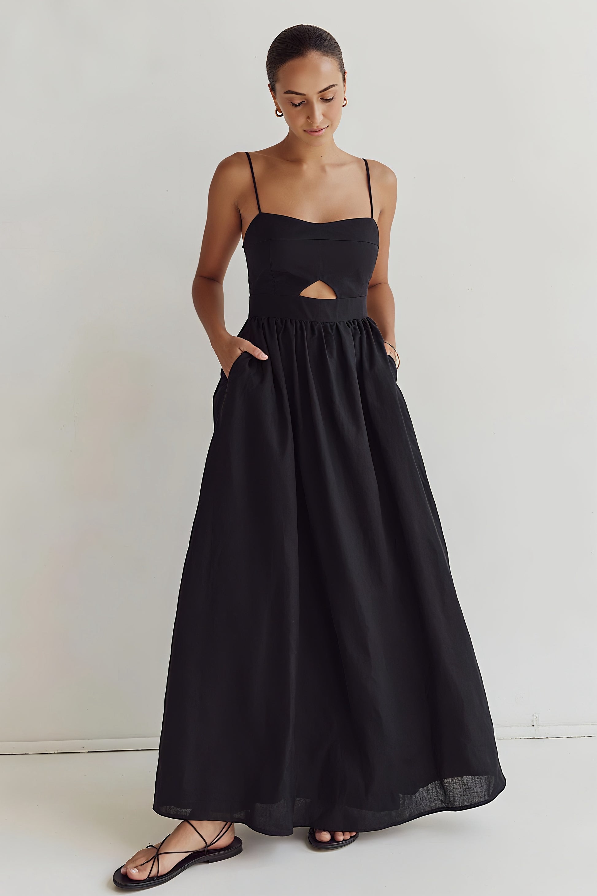 Kaia Dress in black cotton – standing front view with hands on waist

